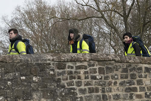Team walk over a bridge in countryside
